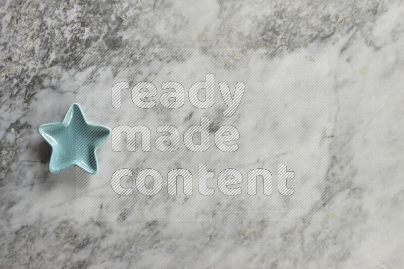 A colored pottery star plate on grey marble background
