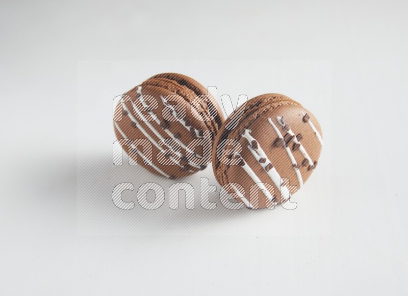 45º Shot of two Brown white Chocolate Caramel macarons on white background