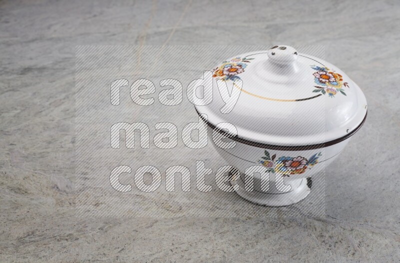 A vintage metal pot on grey marble background