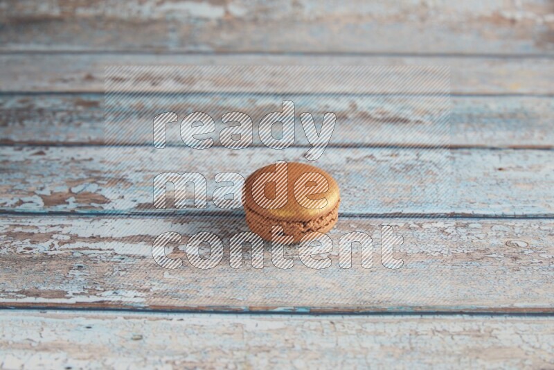 45º Shot of Brown Coffee macaron on light blue wooden background