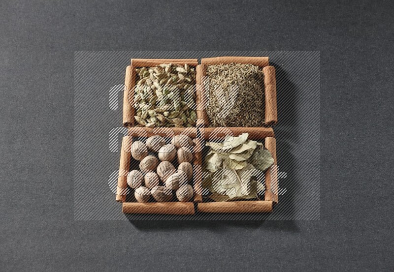 4 squares of cinnamon sticks full of cumin, cardamom, bay laurel leaves and nutmegs on black flooring