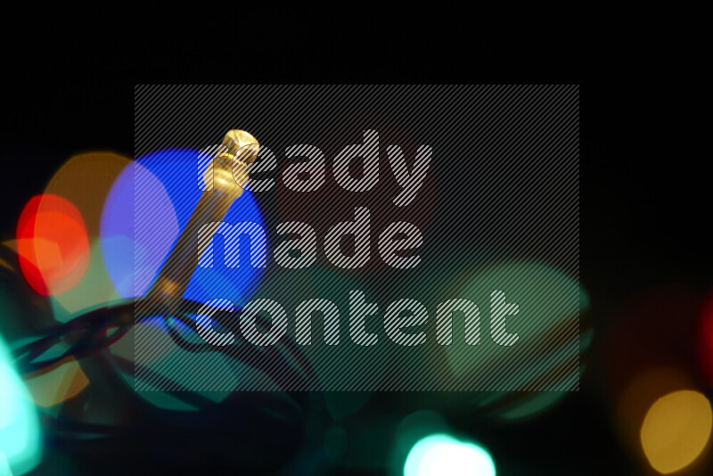 Light bulbs glowing against backdrop of multicolord bokeh