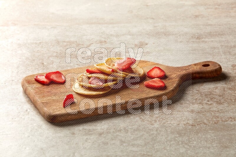 Five stacked strawberry mini pancakes on a wooden board on beige background
