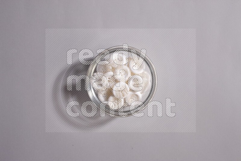 Colored buttons in a glass bowl on grey background