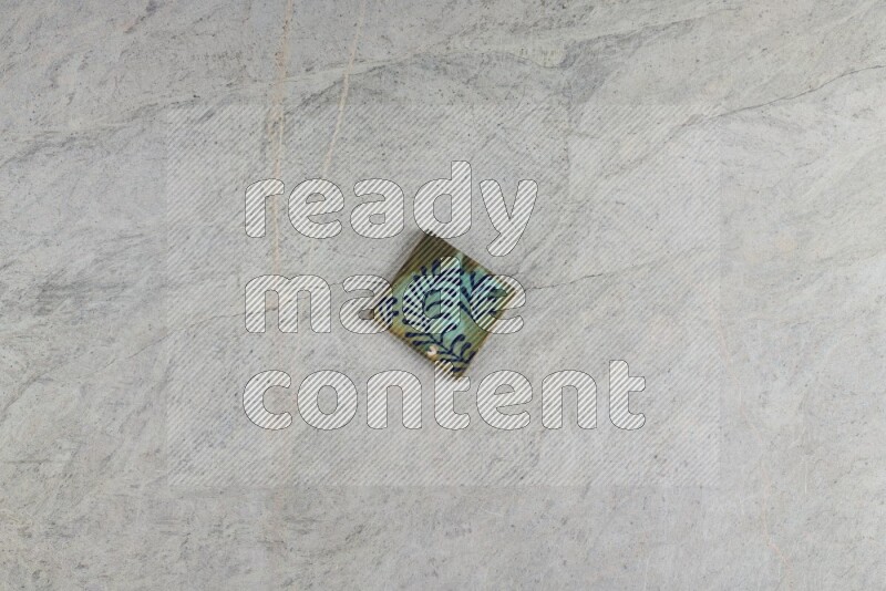 A decorative pottery coaster on grey marble background