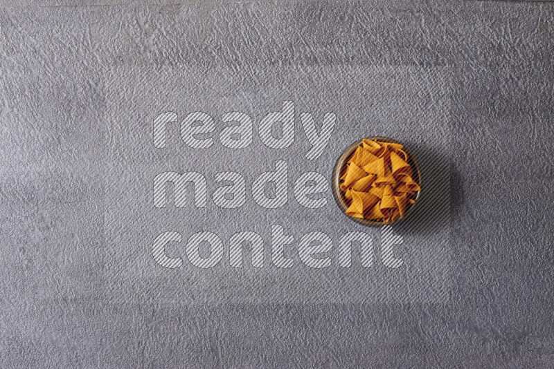 وجبات خفيفة متنوعة في أوعية فخارية على خلفية رمادية