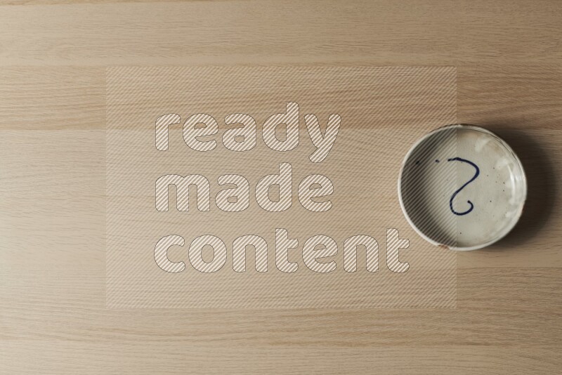 وعاء فخاري متعدد الألوان على خلفية خشبية فاتحة