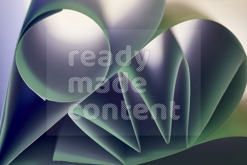 An artistic display of paper folds creating a harmonious blend of geometric shapes, highlighted by soft lighting in green tones