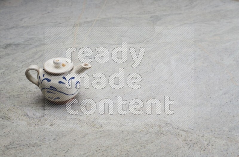 A pottery teapot on grey marble background