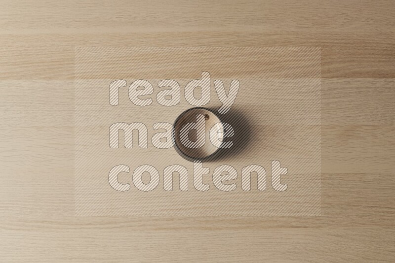 A beige pottery bowl on light wooden background
