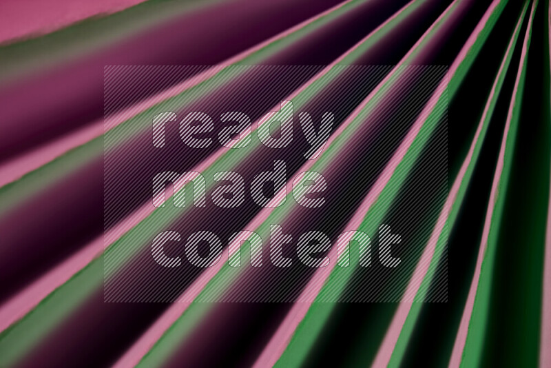 An image presenting an abstract paper pattern of lines in green and pink tones