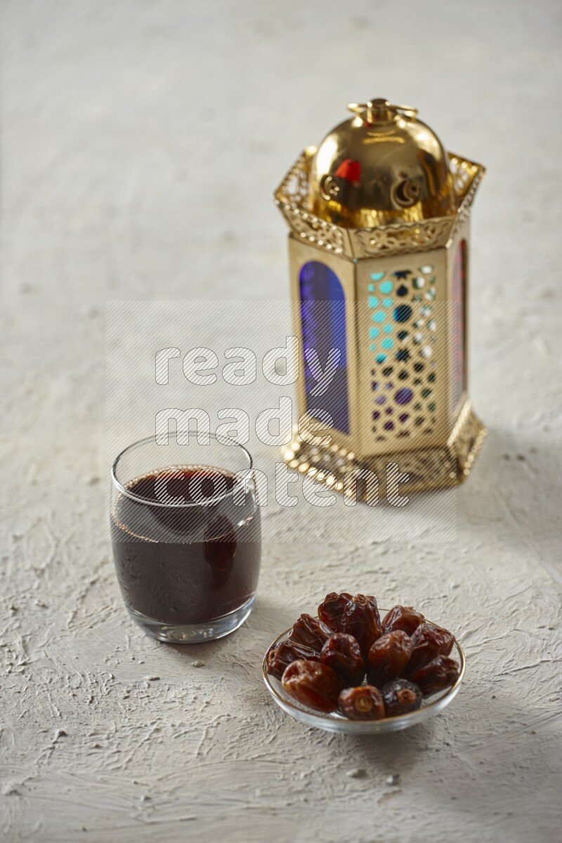 A golden lantern with different drinks, dates, nuts, prayer beads and quran on textured white background