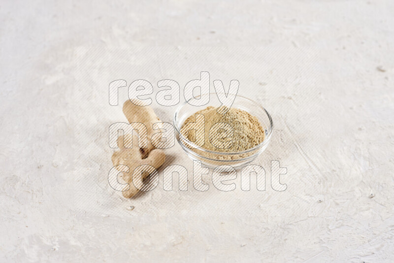 A glass bowl full of ground ginger powder on white background