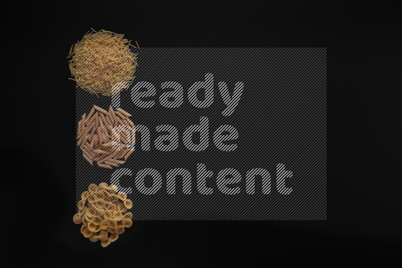 Different pasta types in 3 bunches on black background