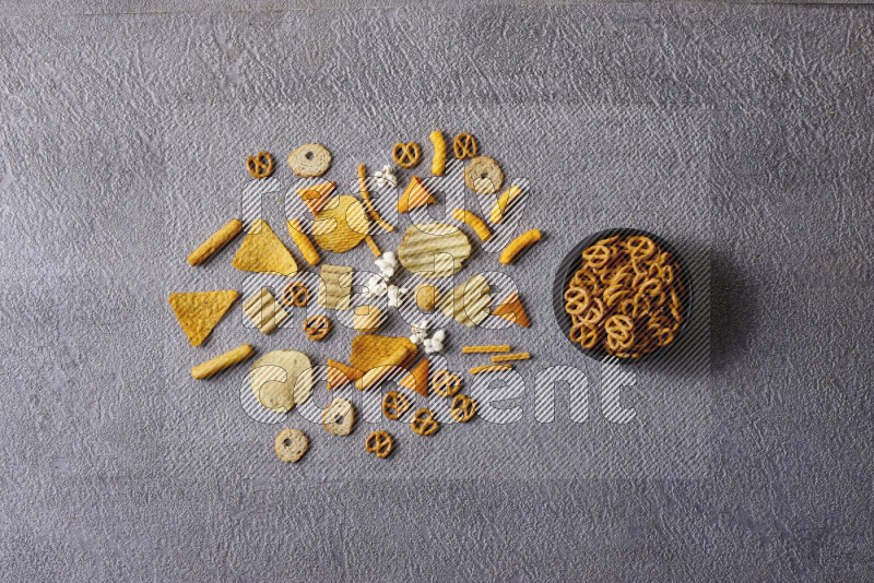 Assorted snacks in pottery bowls on grey background
