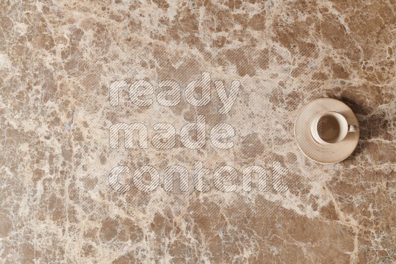 A pottery cup on beige marble background