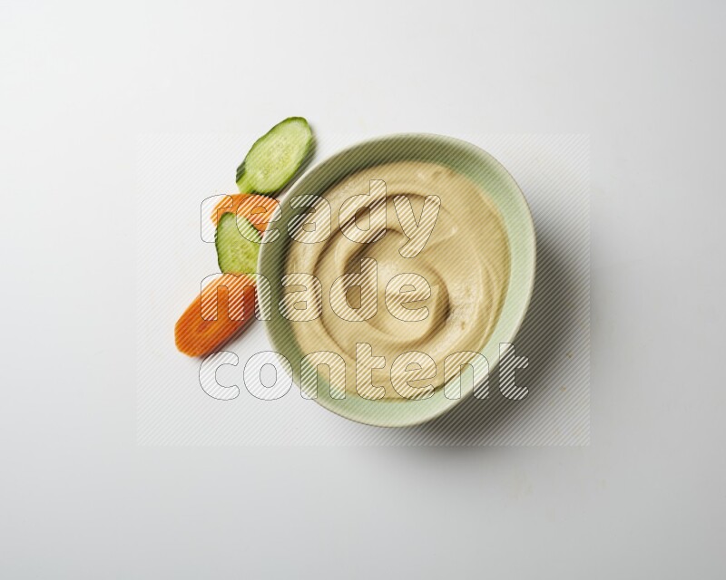 plain Hummus in a green plate on a white background