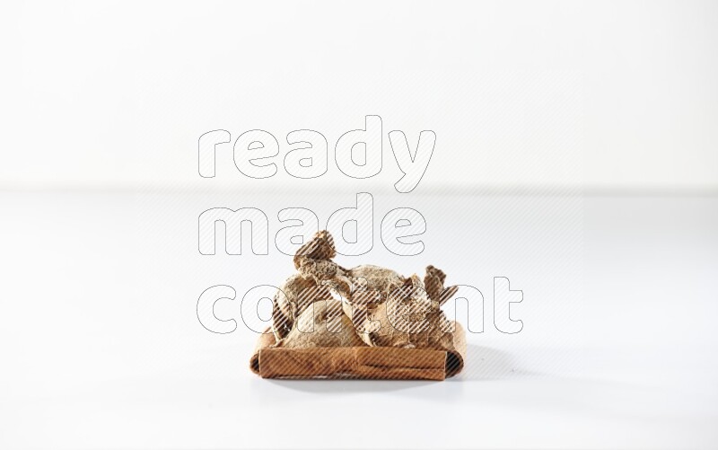 A single square of cinnamon sticks full of dried ginger on white flooring