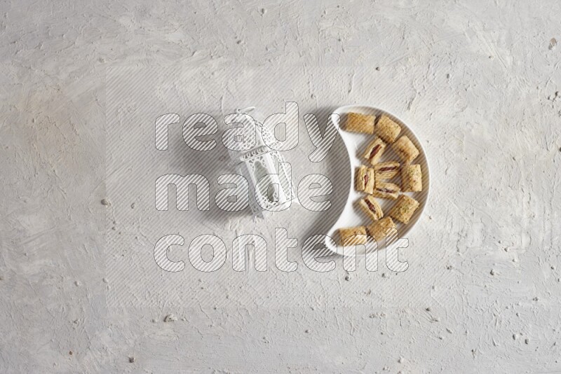 Oriental sweets in a pottery plate with lantern in a light setup