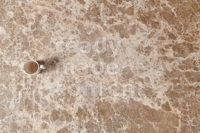 A pottery cup on beige marble background