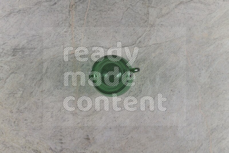 A colored glass jug on grey marble background
