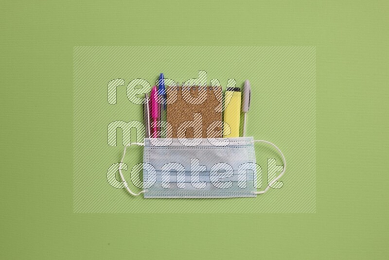 Different school supplies on green background