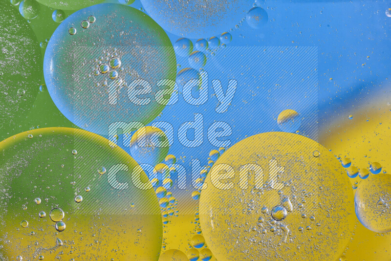 Close-ups of abstract oil bubbles on water surface in shades of yellow, green and blue