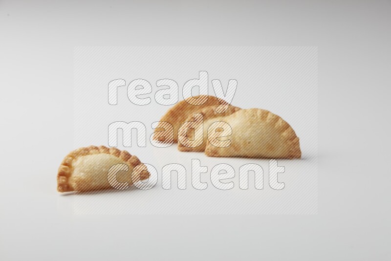 Four fried sambosas on a white background