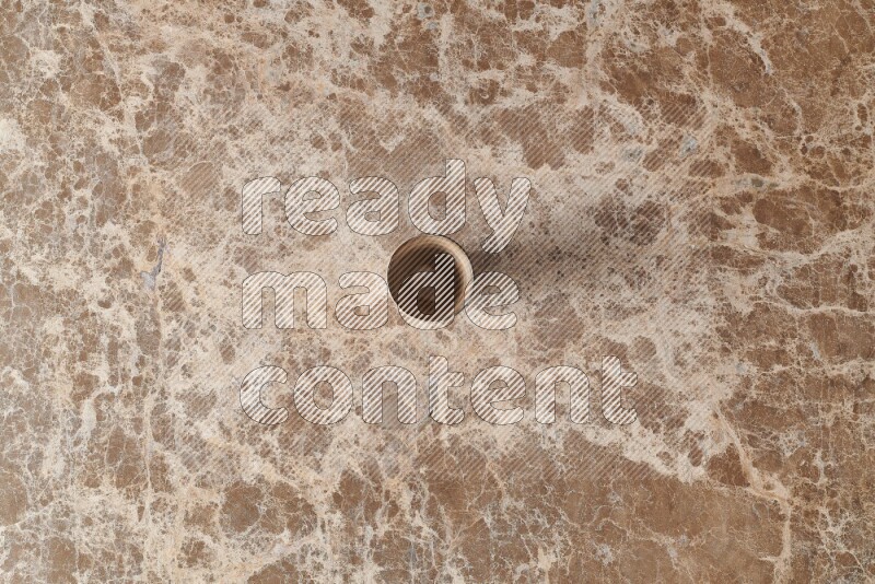 A pottery cup on beige marble background
