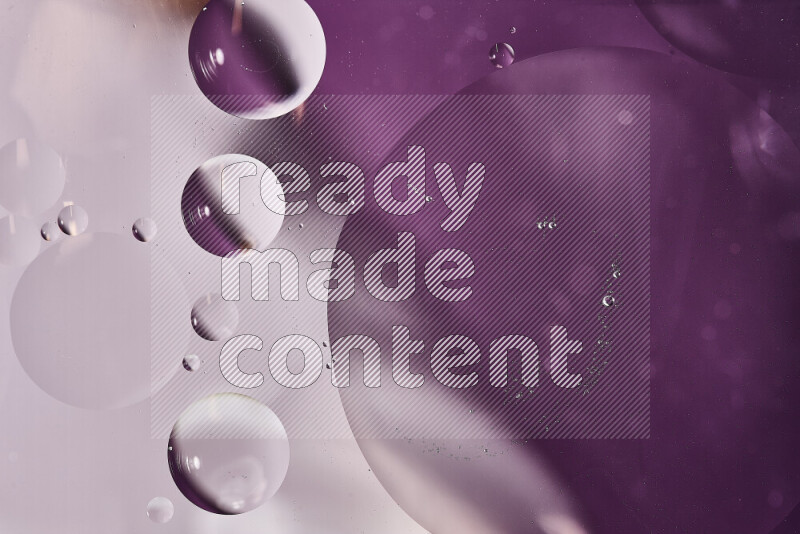 لقطات مقربة لفقاعات من الزيت على سطح الماء باللون الأبيض والأرجواني