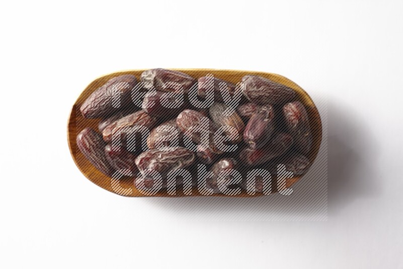 Dates in a wooden plate on white background