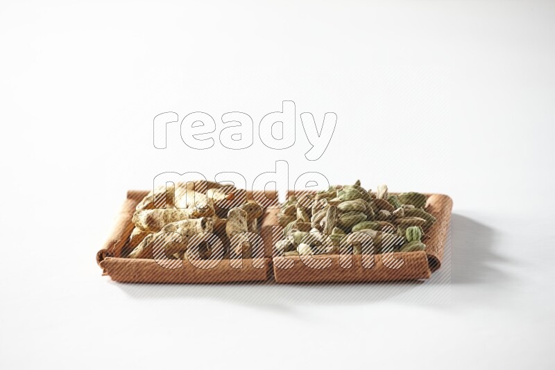 2 squares of cinnamon sticks full of cardamom and turmeric fingers on white flooring