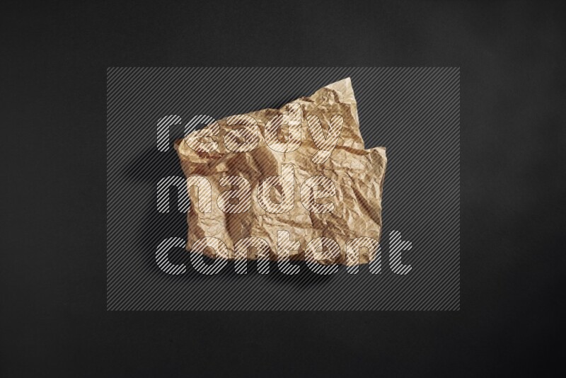 Crumpled craft paper on black background