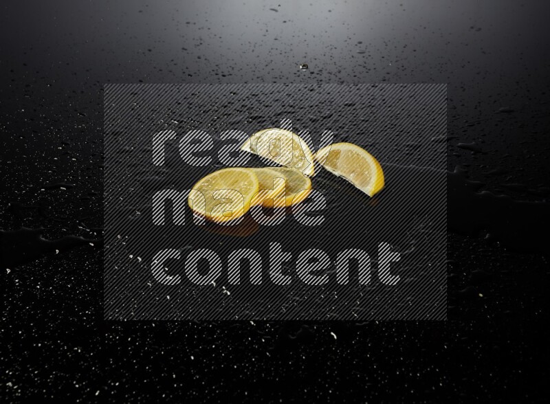 Lemon slices with water drops, and droplets on black background