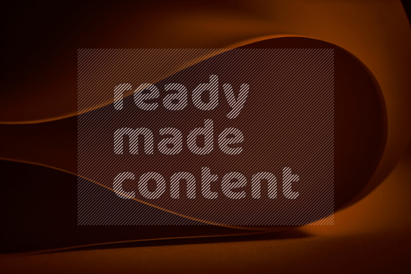 فن تجريدي يعرض منحنيات وتدرجات اللون البرتقالي مكونه بضوء ملون