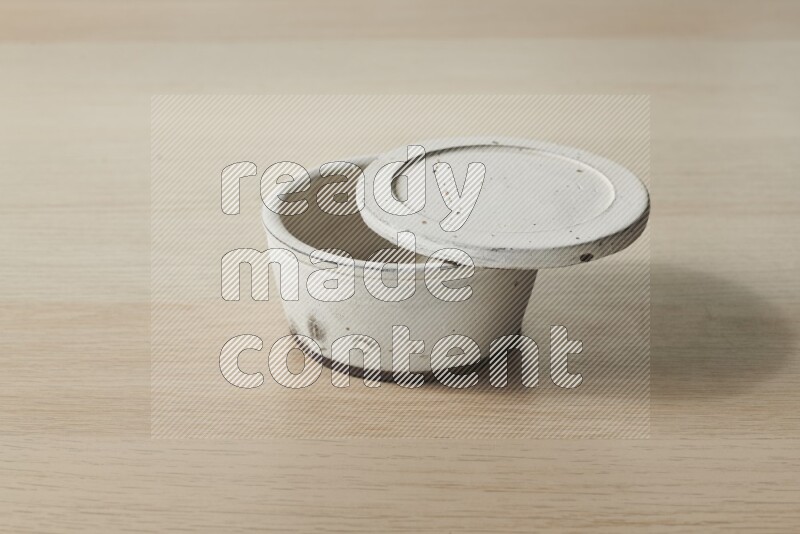 A white pottery bowl on light wooden background