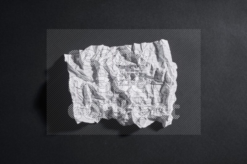 Crumpled notebook sheet on black background