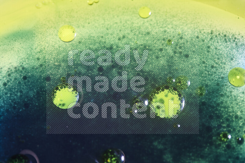 Close-ups of abstract yellow, blue and green watercolor drops on oil Surface on white background