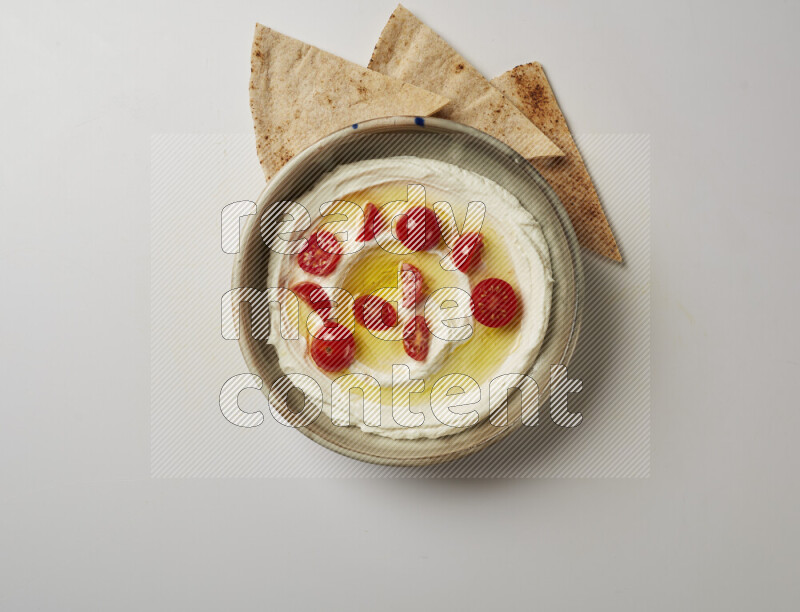 Lebnah garnished with cherry tomato in a grey pottery plate on a white background