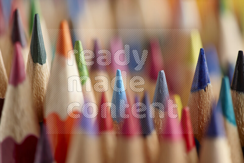 The image captures a close-up of sharpened colored pencils on multicolored background