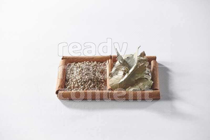 2 squares of cinnamon sticks full of white pepper and bay laurel leaves on white flooring