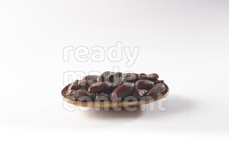 Dates in a wooden plate on white background