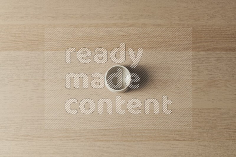 A white pottery bowl on light wooden background