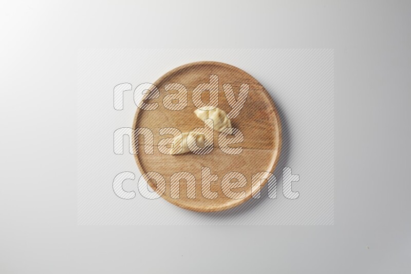 Two Sambosas on a wooden round plate on a white background