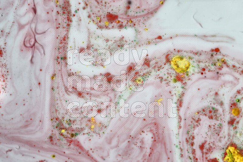 The image captures a splatter of yellow, red and green paint over a white backdrop