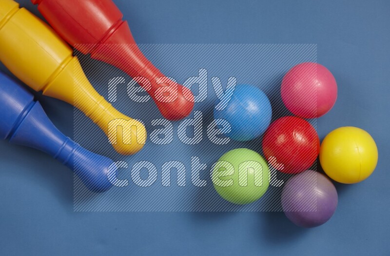 Plastic bowling pins with balls on different colored backgrounds (kids toys)