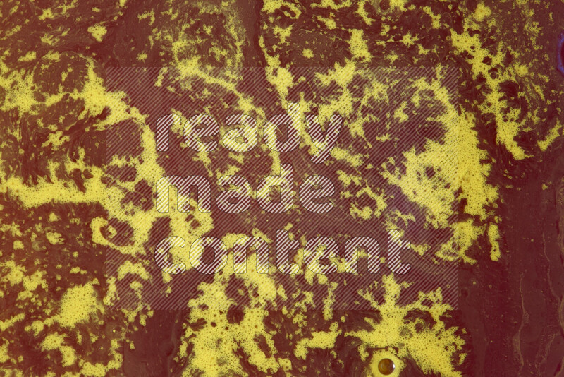 The image depicts a marbling effect with swirling patterns of red and yellow