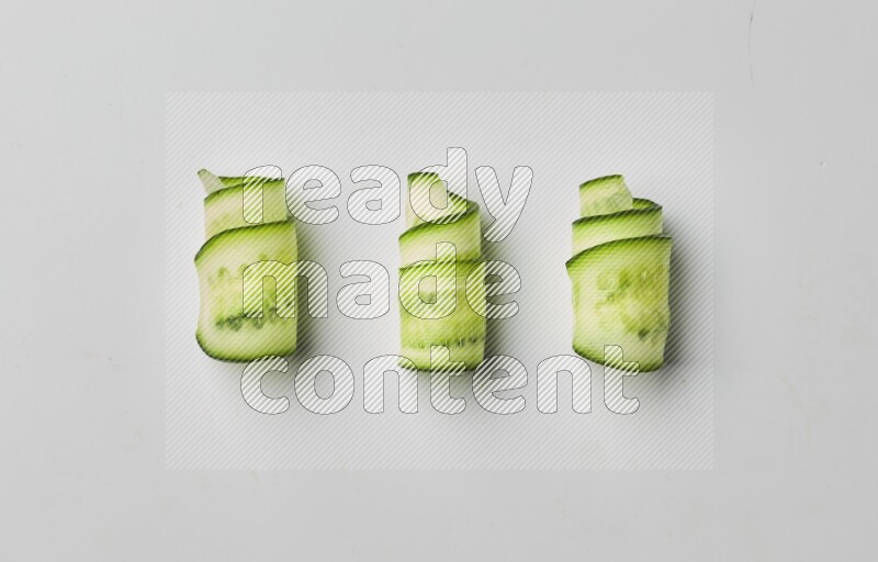 Three cucumber ribbons on a white background