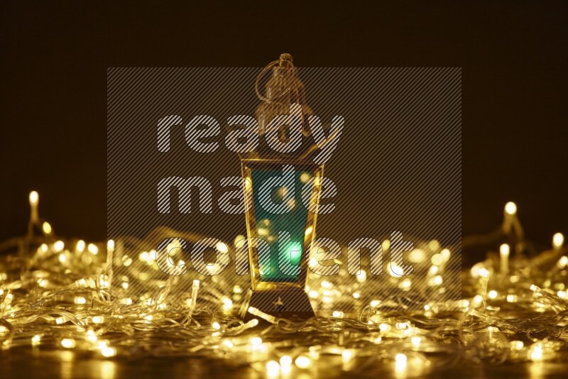 A traditional ramadan lantern surrounded by glowing fairy lights in a dark setup