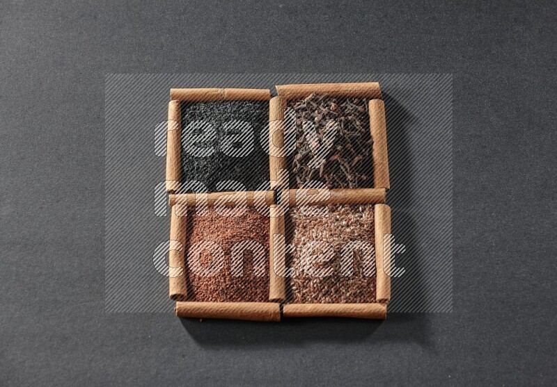 4 squares of cinnamon sticks full of black seeds, garden cress, flaxseeds and cloves on black flooring